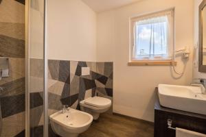 a bathroom with a toilet and a sink at Apartment Ot Residence Bun Sté in San Vigilio Di Marebbe +23 photos