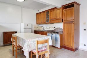 a kitchen with a table and some wooden cabinets at Il Faro in Celle Ligure +25 photos