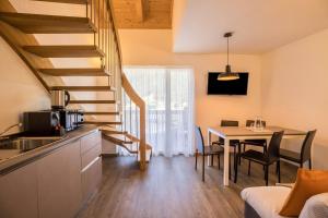 a kitchen and dining room with a table and stairs at Apartment Ot Residence Bun Sté in San Vigilio Di Marebbe