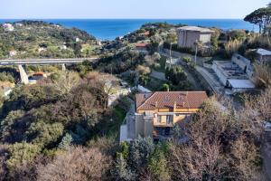 a house on a hill with the ocean in the background at Il Faro in Celle Ligure