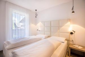 two beds in a room with a window at Apartment Ot Residence Bun Sté in San Vigilio Di Marebbe
