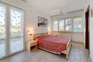 a bedroom with a bed and two windows at Il Faro in Celle Ligure
