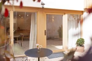 a patio with a table and a glass door at Im Gräbele in Rosenfeld