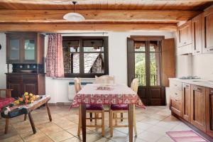 a kitchen with a table and chairs in a room at Genzianella Tano di Grich in Cesani