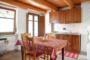 a kitchen with a table and chairs in a room at Genzianella Tano di Grich in Cesani +13 photos