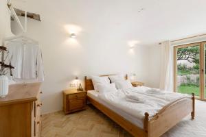 a bedroom with a bed with white sheets and a window at Im Gräbele in Rosenfeld
