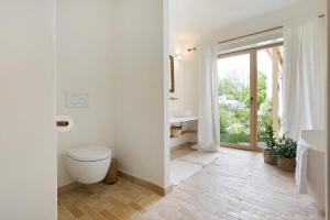 a white bathroom with a toilet and a window at Im Gräbele in Rosenfeld +15 photos