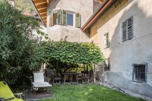 a garden with a table and chairs next to a building at Ferienhaus Weingut Plonerhof in Bolzano