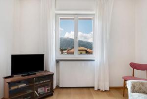 a living room with a television and a window at Casa Marta in Cavalese