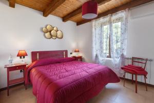 a bedroom with a purple bed and a window at Il Serraglio Rooms in Valeggio sul Mincio