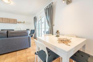a white table in a living room with a couch at White Sands 306 in Arenal d'en Castell