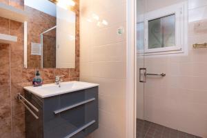 a bathroom with a sink and a shower at La Maison Bleue 3 étoiles in Plouhinec +19 photos
