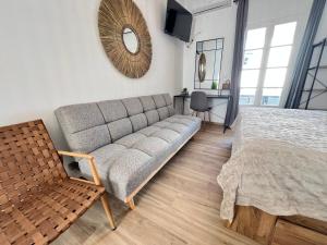 a bedroom with a couch and a table and a mirror at aeolian blu 4 in Parikia