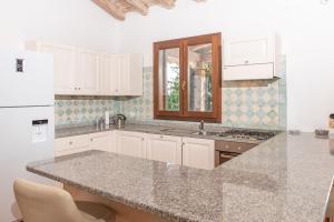 a kitchen with white cabinets and a granite counter top at Villetta Nicola in Olbia