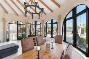 a dining room with a table and chairs and windows at Casa Nero in San Fulgencio