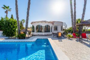 a villa with a swimming pool and palm trees at Casa Nero in San Fulgencio