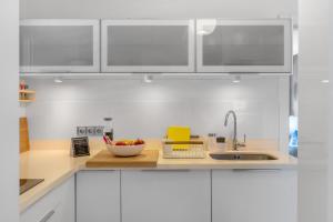 a kitchen with white cabinets and a bowl of fruit on a counter at 51 Avenue Playa Honda in Playa Honda