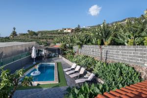 an overhead view of a pool with lounge chairs and a swimming pool at Los Lilos in Tijarafe