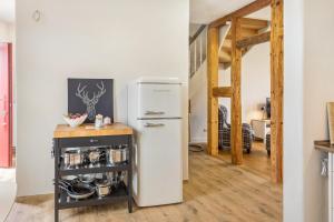 a white refrigerator in a kitchen with a wooden floor at Hof Rosenstein in Helle