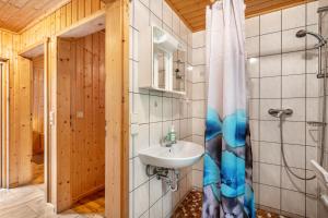 a bathroom with a sink and a shower curtain at Bungalow 18 - Finnhütte in Niesky +12 photos