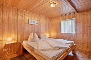 a bedroom with a bed in a wooden room at Bungalow 18 - Finnhütte in Niesky