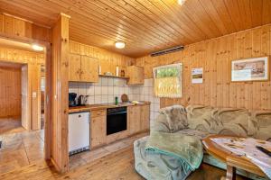 a kitchen with a couch and a table in a room at Bungalow 18 - Finnhütte in Niesky