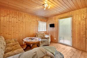 a living room with wooden walls and a table and chairs at Bungalow 18 - Finnhütte in Niesky