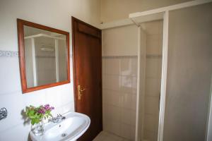 a bathroom with a sink and a shower with a mirror at Casa Da Calçada - Turismo Sortelha in Sortelha +22 photos