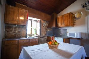 a kitchen with a basket of fruit on a table at Casa Da Calçada - Turismo Sortelha in Sortelha