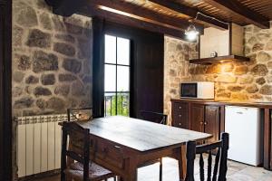 a kitchen with a wooden table in a room at El Rincón Del Duende in Pedro Bernardo