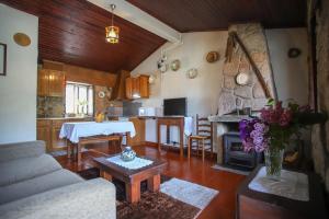 a living room with a couch and a table and a kitchen at Casa Da Calçada - Turismo Sortelha in Sortelha