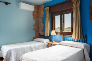 three beds in a room with blue walls and a window at El Rincón Del Duende in Pedro Bernardo +26 photos
