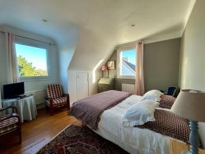 a bedroom with a large bed and two windows at Chambres Er Vingle - Locmariaquer in Locmariaquer