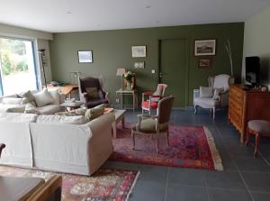 a living room with white furniture and green walls at Chambres Er Vingle - Locmariaquer in Locmariaquer
