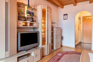 a living room with a tv on a entertainment center at Appartment Bergweg in Laion
