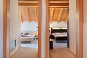 a bedroom with two beds and a room with a bed at Appartment Bergweg in Laion