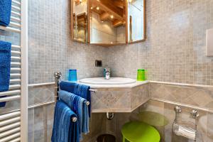 a bathroom with a sink and a mirror and blue towels at Appartment Bergweg in Laion +21 photos
