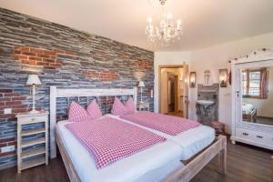 a bedroom with a bed and a brick wall at 5 Sterne Ferienwohnung Sissi in Übersee