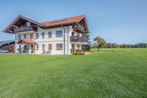 a large house with a large grass yard at 5 Sterne Ferienwohnung Sissi in Übersee