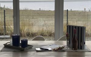 a table with a bottle and two cups on it at Ferienhaus Olpenitz und Strand in Kappeln