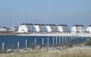 a group of white buildings on a beach next to the water at Ferienhaus Olpenitz und Strand in Kappeln
