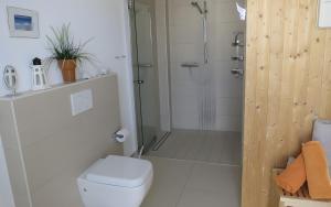 a white bathroom with a shower and a toilet at Ferienhaus Olpenitz und Strand in Kappeln +19 photos