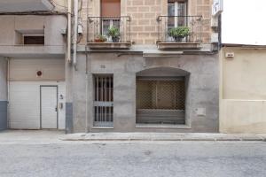 a building with doors and balconies with potted plants at Wonderful loft centre Manresa in Manresa