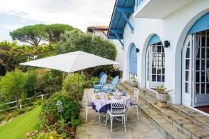 a patio with a table and an umbrella at L'annexe - Chambre in Ciboure