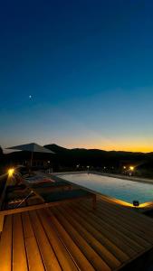a view of a swimming pool at night at Les Chalets De Tesa 4 in Occhiatana