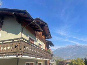 a building with a balcony with mountains in the background at Au Petit Chevrot - Classic in Aosta