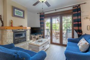 a living room with two blue chairs and a fireplace at Casa en la playa con piscinas A in Puerto Marino