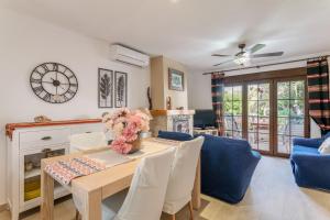 a dining room with a table and a clock on the wall at Casa en la playa con piscinas A in Puerto Marino