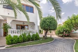 a house with a palm tree and a driveway at Casa en la playa con piscinas A in Puerto Marino