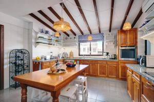 a large kitchen with wooden cabinets and a wooden table at La Casa de Manuel in Estepona